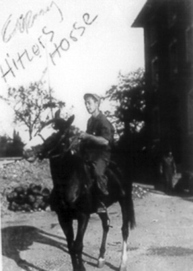 Riding on a horse at Hitler's stable; AH monogramed on saddle.