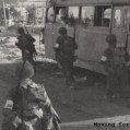 Troops moving past derelict, Toulon France Bus.