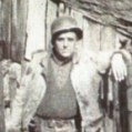 unidentified soldier leaning on a fence