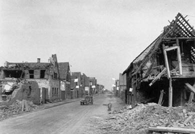 Each house in a German village displays a white flag of surrender.